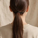 Back view of long hair in a neat sleek low ponytail for everyday wear